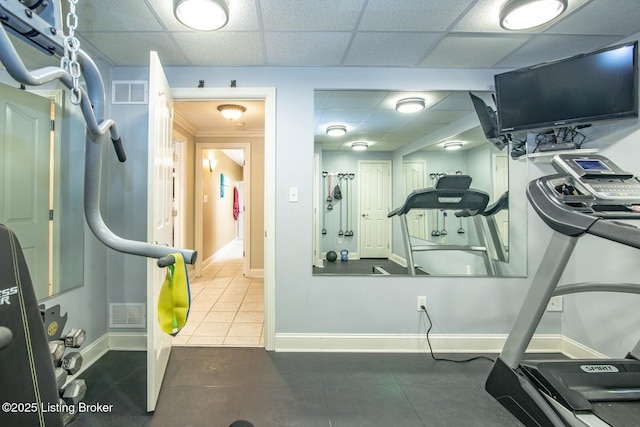 workout area featuring baseboards, visible vents, tile patterned flooring, and a drop ceiling