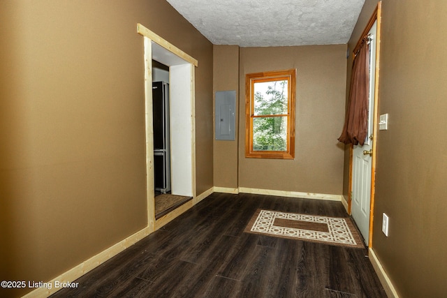 corridor featuring a textured ceiling, baseboards, dark wood-style floors, and electric panel