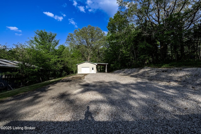 exterior space featuring a garage, driveway, and a wooded view