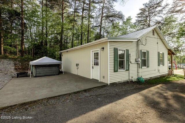 view of property exterior featuring a hot tub and metal roof