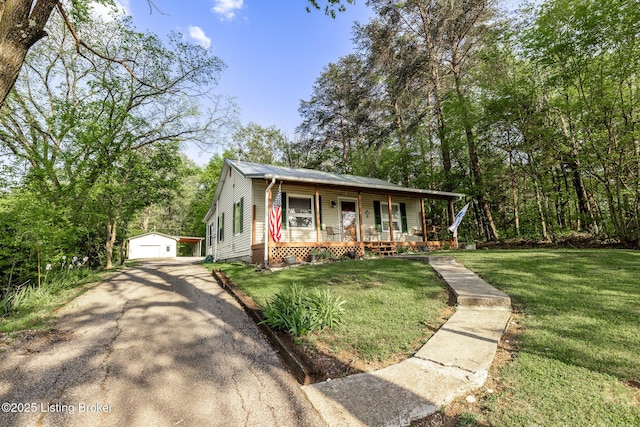 view of front facade with a porch, an outdoor structure, a front yard, and a detached garage