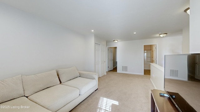 living room featuring recessed lighting, visible vents, baseboards, and light colored carpet