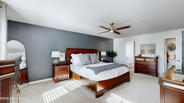 bedroom with light carpet, baseboards, connected bathroom, and ceiling fan
