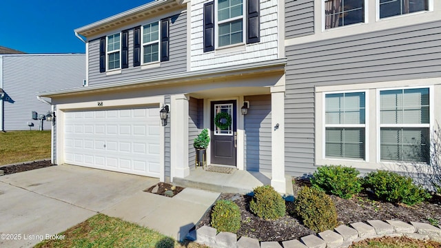 view of exterior entry featuring driveway and a garage