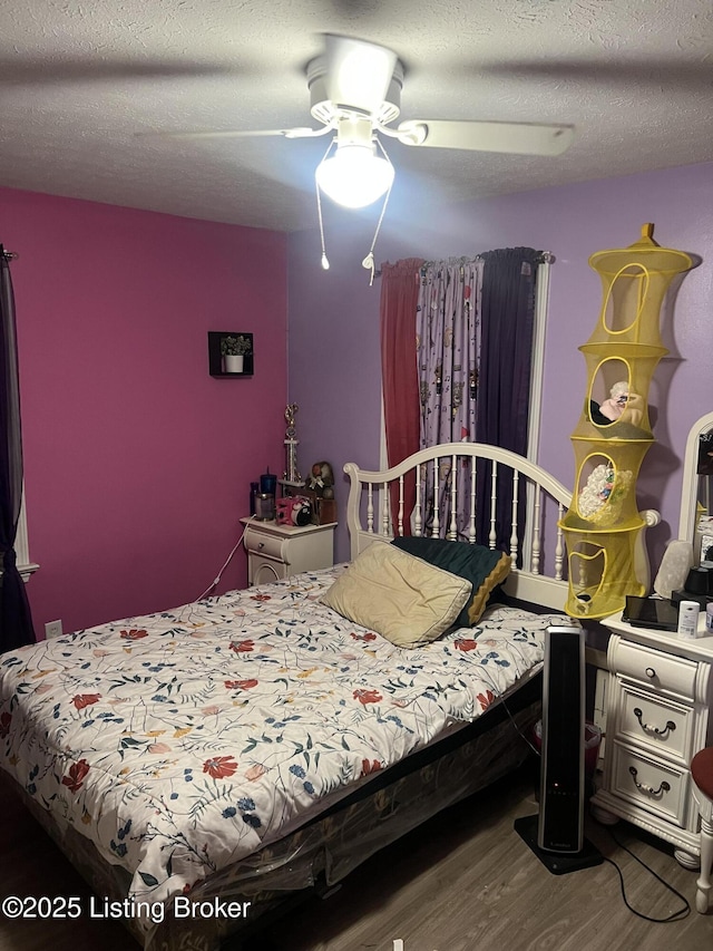 bedroom featuring wood finished floors, a textured ceiling, and ceiling fan