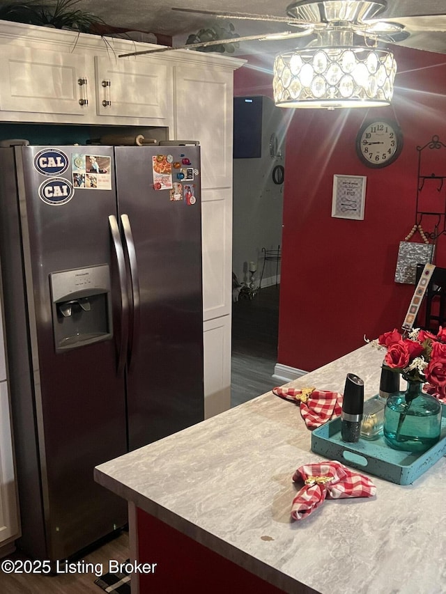kitchen with light countertops, stainless steel fridge, and white cabinets