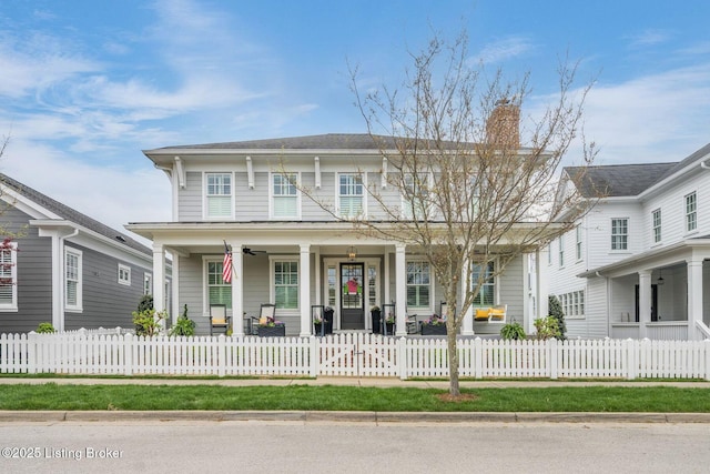 view of front of home with a chimney, a fenced front yard, a ceiling fan, and covered porch