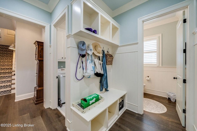 mudroom featuring wainscoting, washer / dryer, a decorative wall, and dark wood finished floors