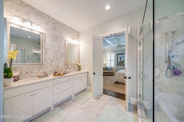 ensuite bathroom with double vanity, a stall shower, baseboards, recessed lighting, and ceiling fan