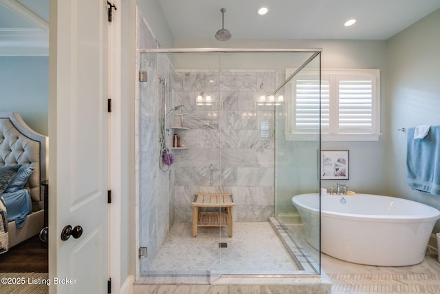 bathroom featuring recessed lighting, a freestanding tub, and a stall shower