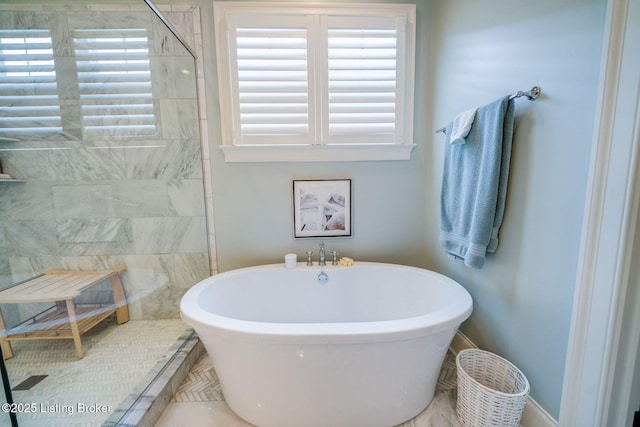 full bathroom with a freestanding bath, a walk in shower, and plenty of natural light