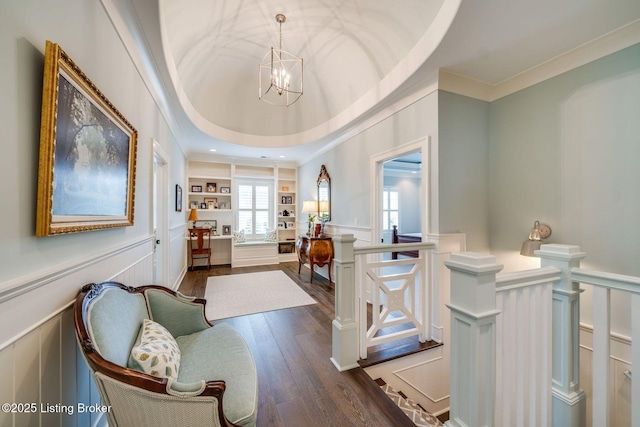 interior space with a decorative wall, crown molding, and an upstairs landing
