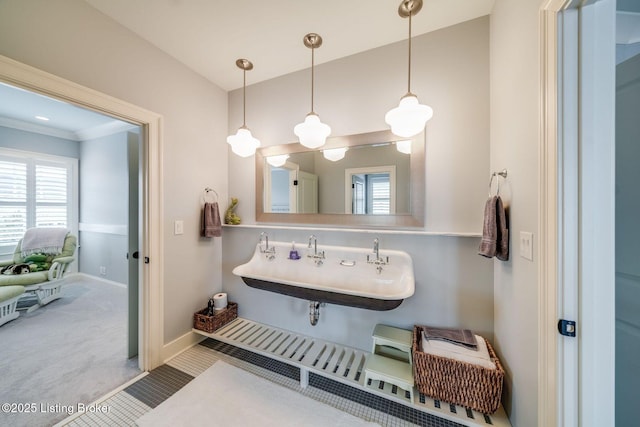 bathroom featuring baseboards, a healthy amount of sunlight, a sink, and tile patterned floors