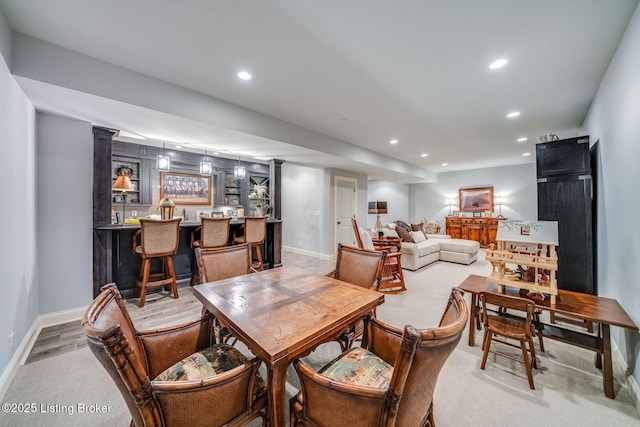 carpeted dining room with recessed lighting, baseboards, and bar