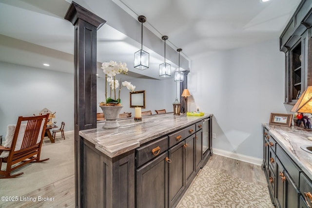 kitchen featuring pendant lighting, light wood finished floors, baseboards, light stone countertops, and recessed lighting