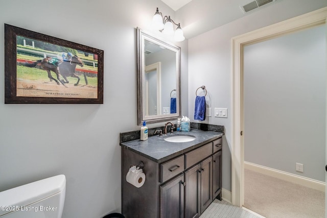 bathroom featuring baseboards, visible vents, vanity, and toilet