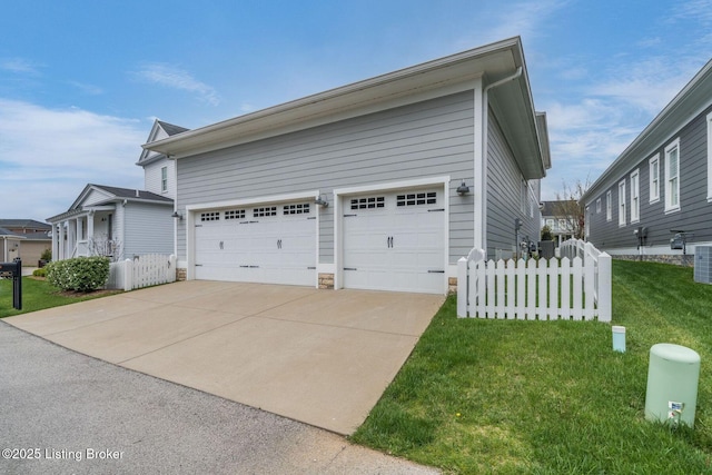 view of side of property featuring a lawn, cooling unit, fence, and driveway