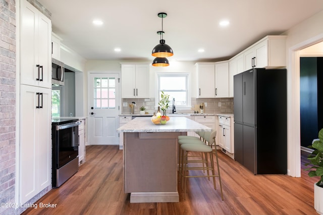 9004 Old Bardstown Rd Rd, Louisville, KY 40291 - kitchen featuring stainless steel appliances, white cabinets, wood finished floors, tasteful backsplash, and recessed lighting