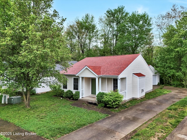 bungalow-style home with covered porch, a front lawn, and roof with shingles
