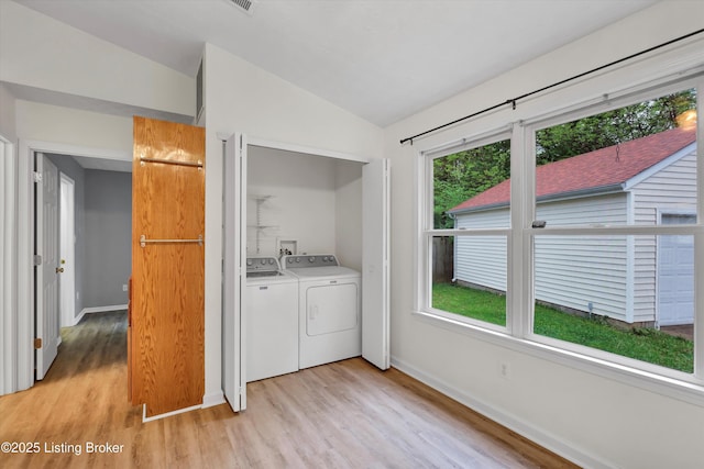laundry room with light wood finished floors, baseboards, washer and dryer, and laundry area