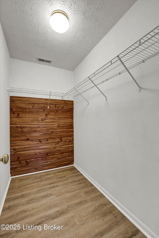 walk in closet featuring light wood-style flooring and visible vents