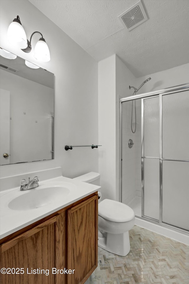 bathroom featuring a shower stall, visible vents, toilet, and vanity
