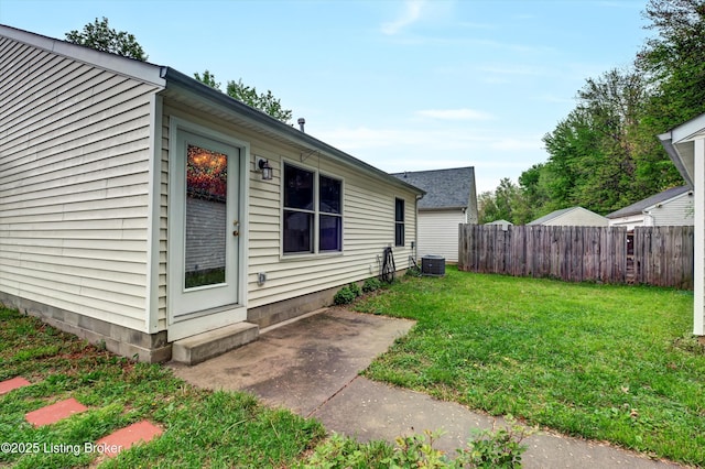 view of home's exterior with fence, entry steps, a yard, and central AC unit