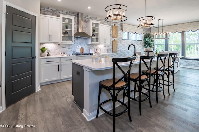 10535 Vista View Dr, Louisville, KY 40291 - kitchen with dark wood-style floors, light countertops, wall chimney exhaust hood, decorative backsplash, and a kitchen island with sink