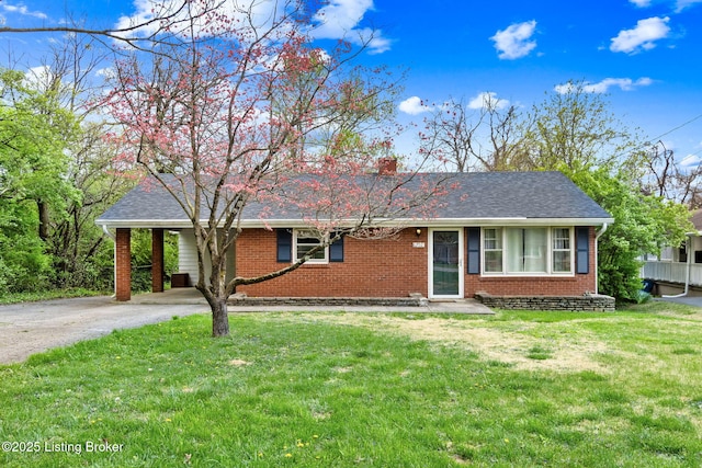 ranch-style house featuring concrete driveway, a front lawn, a chimney, a carport, and brick siding