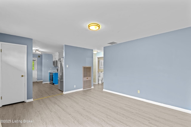 unfurnished living room with baseboards, light wood finished floors, and visible vents
