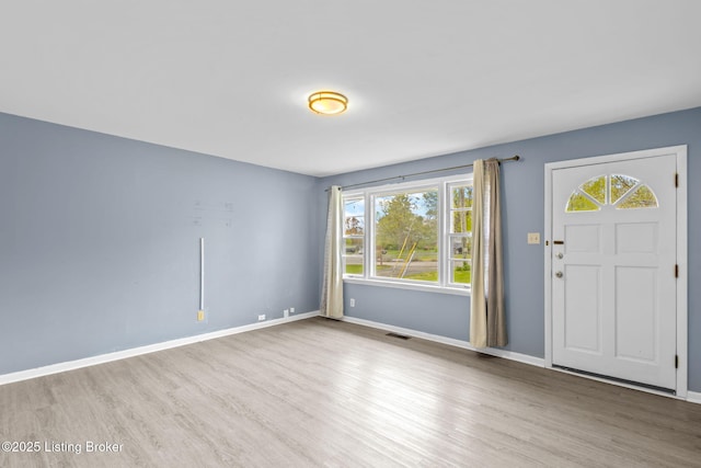 foyer entrance featuring wood finished floors, visible vents, baseboards, and plenty of natural light