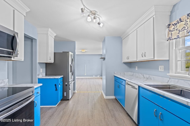 kitchen featuring blue cabinetry, appliances with stainless steel finishes, white cabinets, and light wood-type flooring