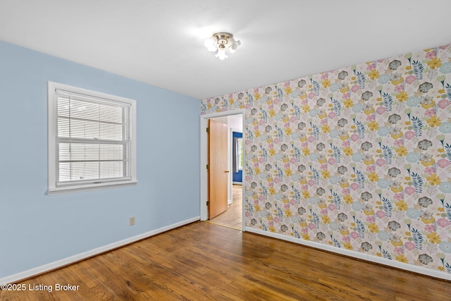 unfurnished room featuring wood finished floors and baseboards
