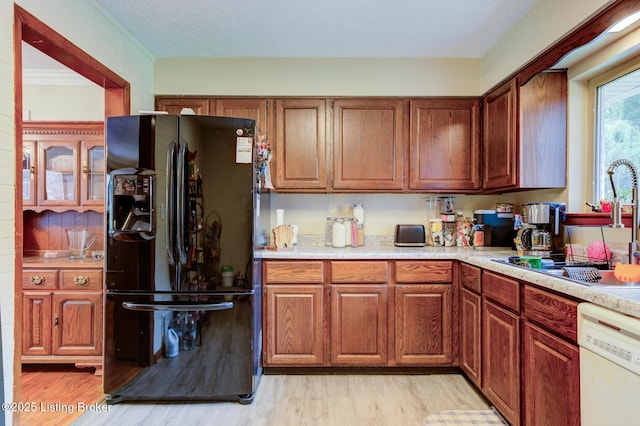 7105 Woodrow Way, Louisville, KY 40228 - kitchen featuring freestanding refrigerator, white dishwasher, light countertops, light wood-type flooring, and brown cabinets