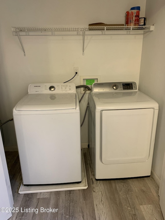 1015 E Muhammad Ali Blvd, Louisville, KY 40204 - laundry area with wood finished floors and washer and clothes dryer