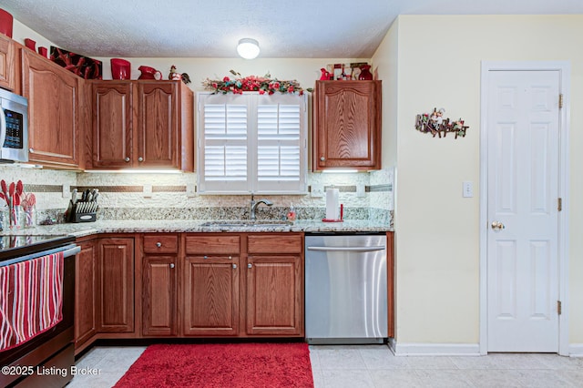 12305 Dominion Way, Louisville, KY 40299 - kitchen featuring light stone counters, tasteful backsplash, a sink, brown cabinetry, and appliances with stainless steel finishes