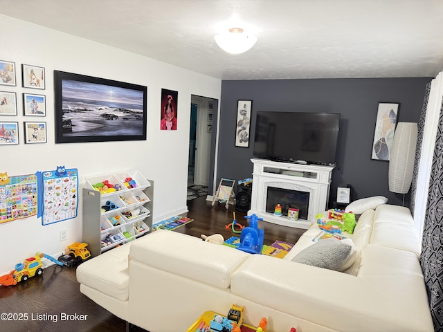 living room with a high end fireplace, wood finished floors, and baseboards