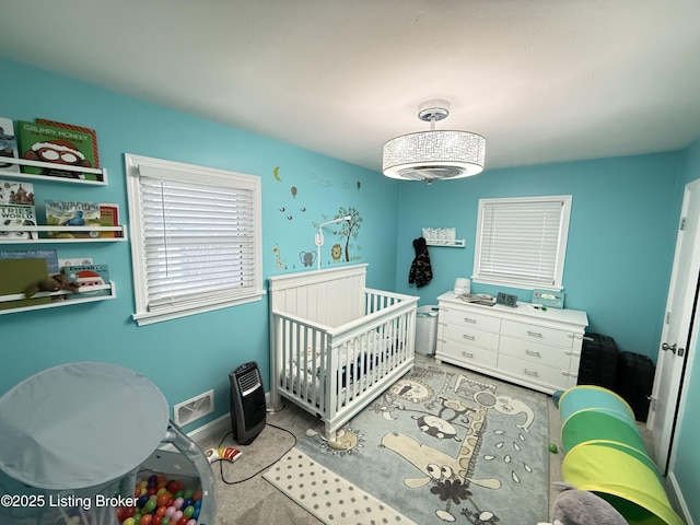 bedroom featuring a crib and baseboards