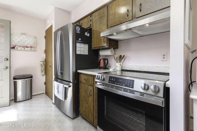 kitchen featuring under cabinet range hood, stainless steel appliances, and light countertops