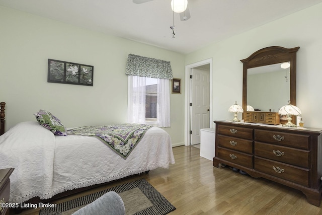 bedroom featuring wood finished floors, baseboards, and ceiling fan