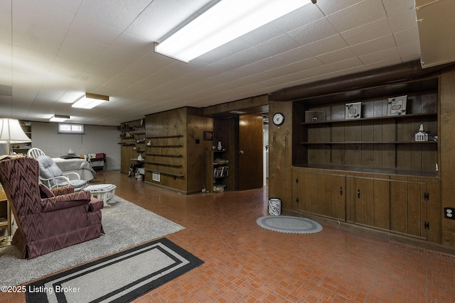 living room with wood walls and brick patterned floor