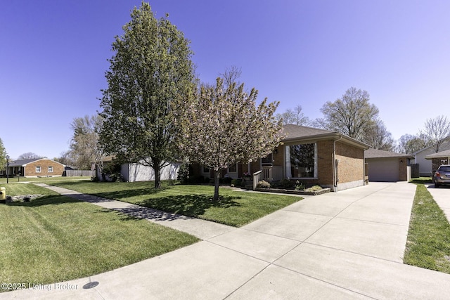 view of property hidden behind natural elements with brick siding, a detached garage, and a front yard