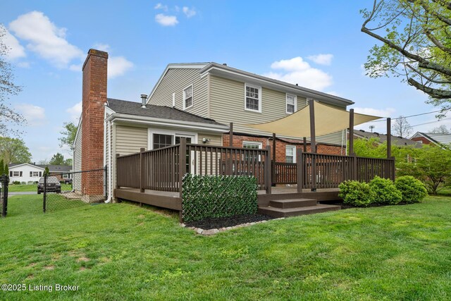 rear view of property featuring a chimney, a wooden deck, and a yard