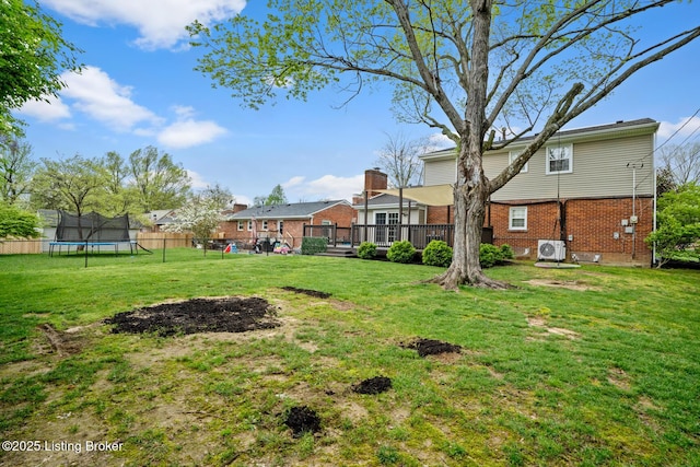 view of yard featuring fence, a wooden deck, ac unit, and a trampoline