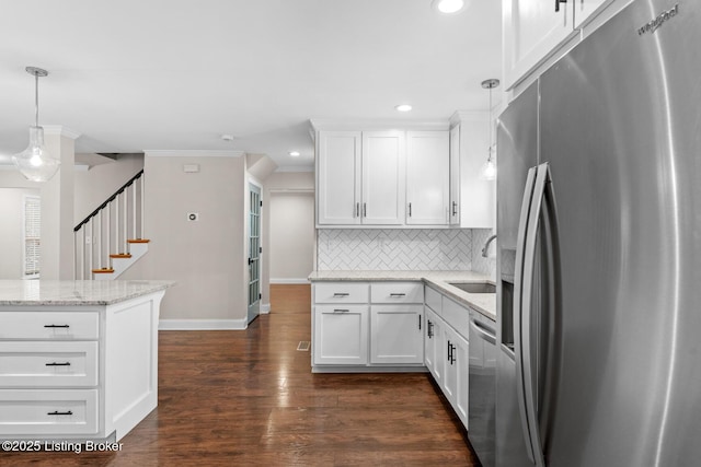 kitchen featuring stainless steel appliances, a sink, tasteful backsplash, baseboards, and white cabinetry