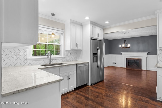 kitchen featuring white cabinets, appliances with stainless steel finishes, dark wood-type flooring, and a sink