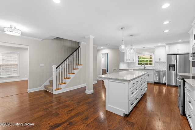 kitchen with dark wood-style flooring, tasteful backsplash, appliances with stainless steel finishes, ornamental molding, and a kitchen island