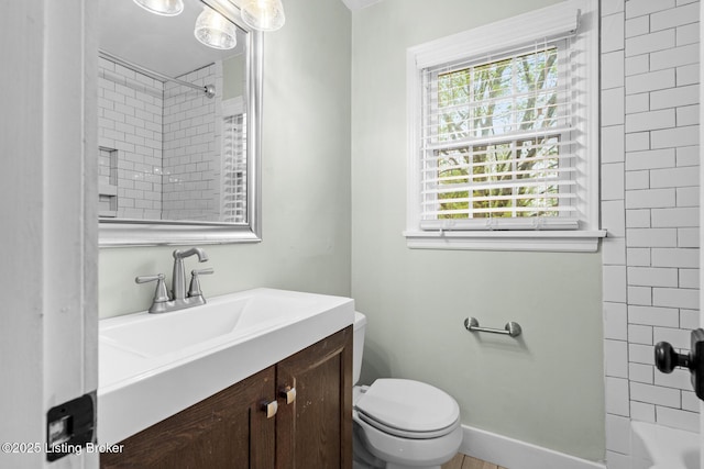 bathroom with baseboards, vanity, shower / tub combination, and toilet