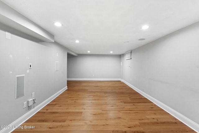 finished basement with baseboards, visible vents, light wood finished floors, and recessed lighting