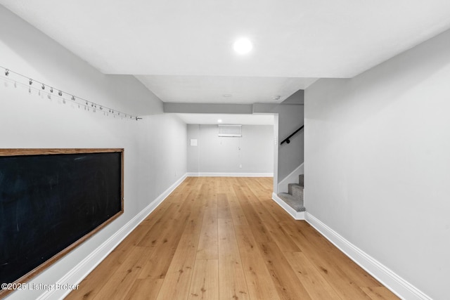 finished below grade area with recessed lighting, light wood-style floors, baseboards, and stairs